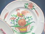 three plates with flowers painted on them sitting on a table