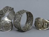 three silver rings and a silver ring with a cross on it