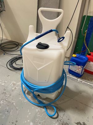 a white container with a blue hose and a blue handle