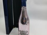 une bouteille de vin rosé dans un coffret noir avec un couvercle bleu