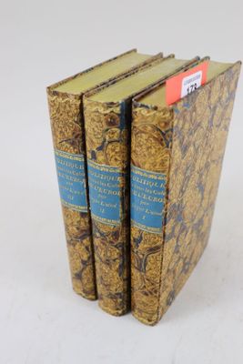 trois livres sont empilés sur une surface blanche
