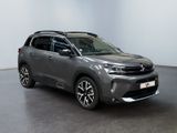 a grey suv parked in a room with a white wall