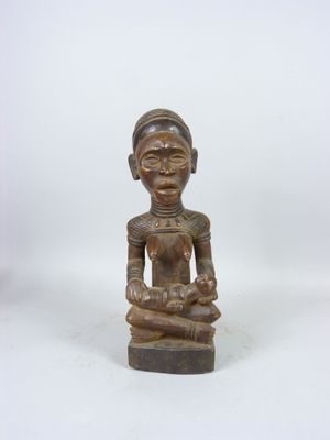 une statue en bois représentant une femme tenant un bébé dans ses bras