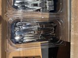 a bunch of forks and spoons in a plastic container