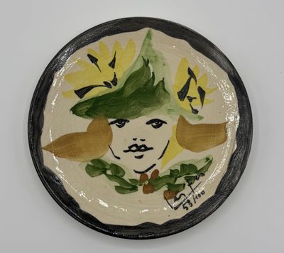 une assiette sur laquelle est représentée une femme portant un chapeau