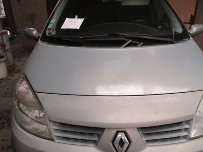une voiture argentée garée dans un garage, avec un autocollant sur le capot