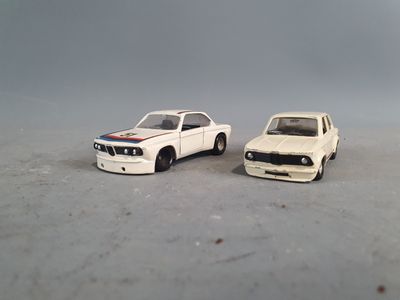 two toy cars sitting next to each other on a table