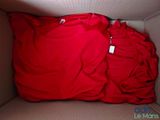 un t-shirt rouge dans une boîte sur laquelle est accrochée une étiquette