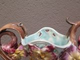 a vase with a handle that has flowers on it