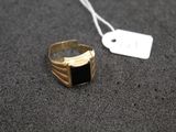 a close up of a gold ring with a black stone on it