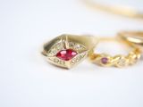 two gold rings with a red stone on top of them