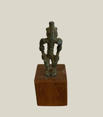 an image of a bronze statue of a man on a wooden block