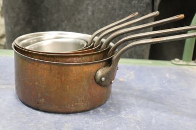 three metal pots with spoons in them on a table