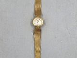an image of a gold wrist watch with a chain around it