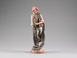 an old statue of a man with a beard and a red hat
