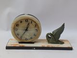 a clock with a bird figurine on a stand