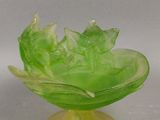 un bol en verre vert orné d'un motif de feuilles
