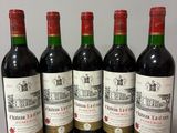 six bouteilles de vin rouge sont alignées sur une table
