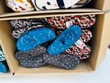 many pairs of slippers in a box on a table