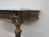 a marble top table with a brass base and a marble top