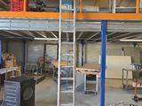une photo d'un garage avec une échelle au milieu