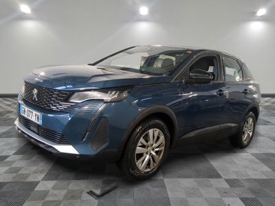 une voiture bleue garée dans une pièce au sol en damier