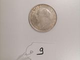 a close up of a coin on a white surface with a price tag