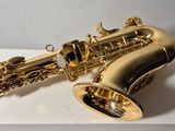 a close up of a gold saxophone on a white surface