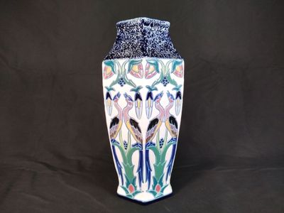 un vase orné d'un motif d'oiseau sur fond noir