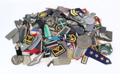 a pile of assorted military badges on a white surface