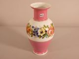 a pink and white vase with flowers painted on it