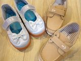 three pairs of children ' s shoes sitting on a wooden floor