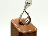 a silver ring sitting on top of a wooden box