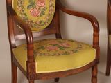 pair of antique chairs with floral upholstered cushions and wooden legs