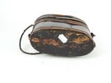 a small black bag with a brown handle on a white surface