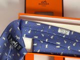 tie in a gift box with a blue tie with white cats on it