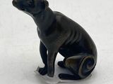 a black dog figurine sitting on a white surface