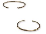 une paire de bracelets manchette en laiton sur fond blanc