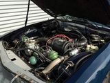 a blue car with its hood open and the engine in the trunk