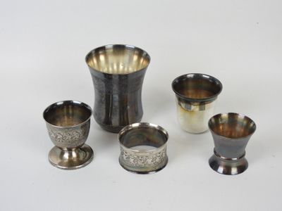 quatre coupes en argent et un vase en argent posés sur un plateau blanc