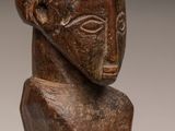 a close up of a wooden statue of a person with a hat on