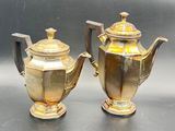 two silver and gold teapots sitting on a table