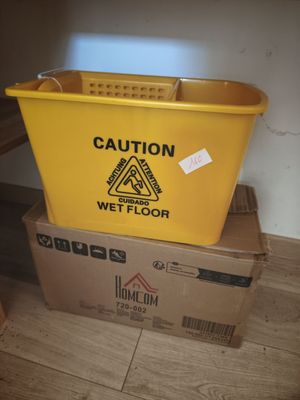 a yellow bucket sitting on top of a box on the floor