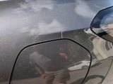 a reflection of a man riding a skateboard on the side of a car