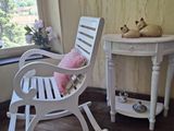 un fauteuil à bascule blanc et une table dans une pièce