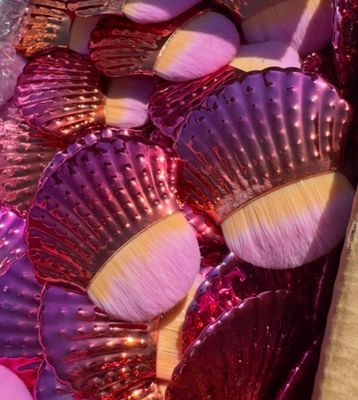 purple and gold scallop shells are arranged on a table