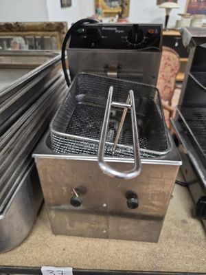 une grande friteuse posée sur un plan de travail dans une cuisine