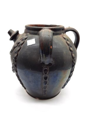 un vase noir posé sur une surface blanche