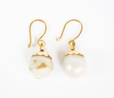 a pair of earrings with a white pearl on a gold plated hook