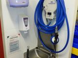 un tuyau bleu fixé au mur à côté d'un lavabo